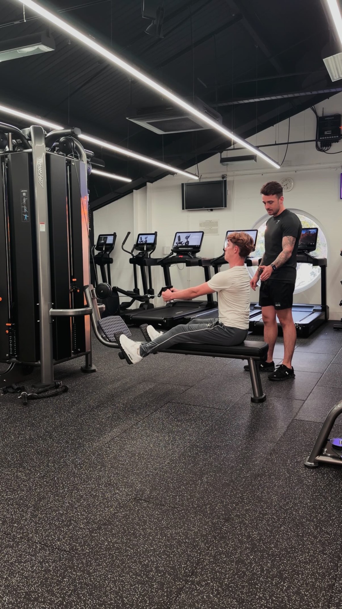 Joe Angelo coaching a client during a seated cable row at Putlands Gym